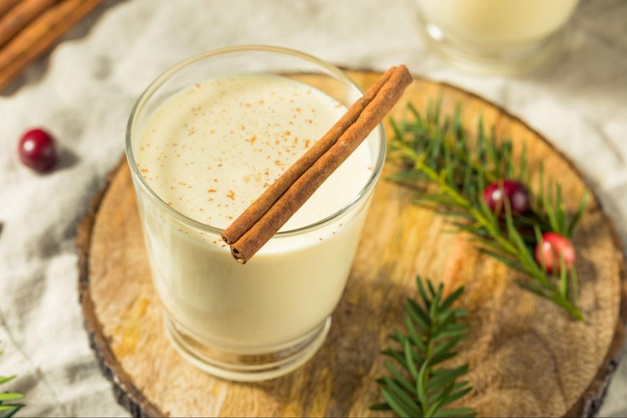 A glass of milk with cinnamon and cranberries