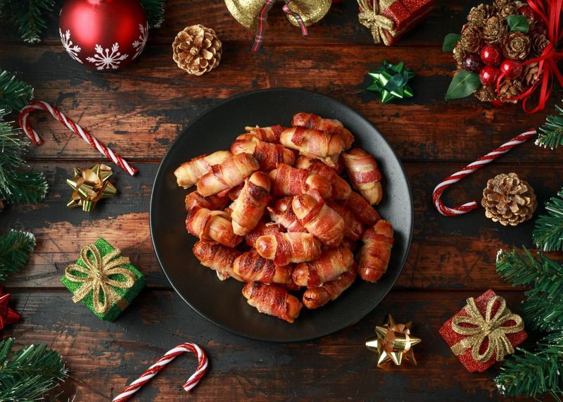 pigs in blankets with christmas decorations on a plate.