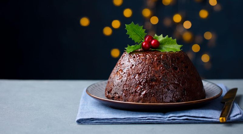 Christmas pudding on a plate with holly leaves